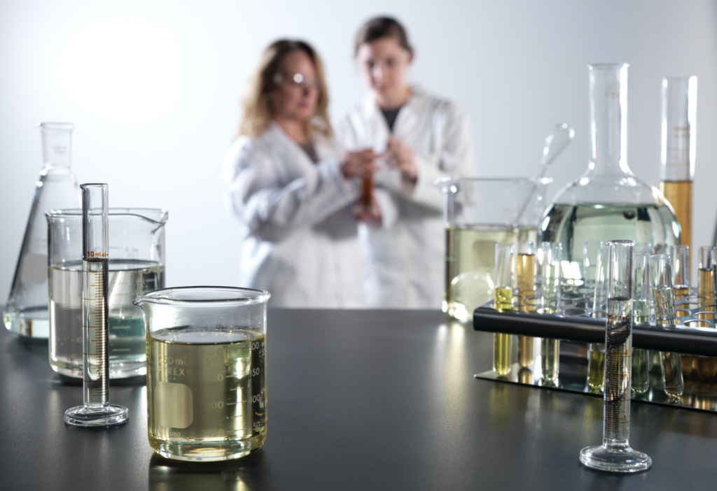 An image of quality control specialist and a lab engineer examining a formula of Synova Release Agents supports Bundy Baking Solutions press release for the new Synova brand.